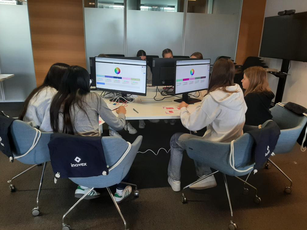 Mehrere Mädchen sitzen an Bildschirmen und suchen dort ihre Wunschfarben für ihre Gestaltung des Blogs